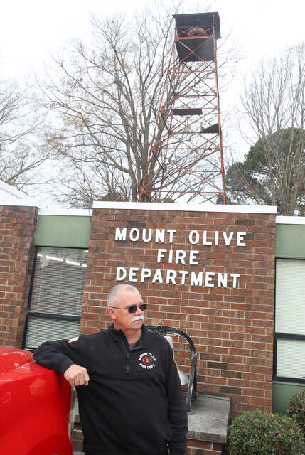 129190126_web1_Siren-1
Mount Olive Fire Chief Greg Wiggins stands in front of the fire station. Wiggins appeared before the Mount Olive Town Board on Dec. 13 to address concerns he and firefighters have about negative social media comments about the use of the fire siren that is located on the tower in the background. Such negative comments, as well harassment of firefighters at call scenes, are contributing to the shortage of volunteers, Wiggins said (Steve Herring|mountolivetribune.com)