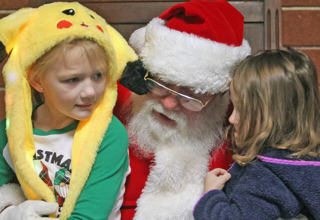 129212274_web1_Masonic-Santa
Santa listens intently as Jennifer Graham whispers her Christmas wish list to him Christmas Eve morning during the annual Christmas Eve community breakfast sponsored by Mount Olive Masonic Lodge No. 208. Her sister Madelyn Davis, 7, waits to talk to Santa (Steve Herring|mountolivetribune.com)