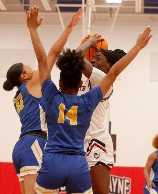 129281914_web1_SW-EWake-G1
Southern Wayne senior TaNiyah Glaspie attempts a shot against East Wake defenders Kelsea McNair, left, and Amanda Pulley, front, during third-period play Wednesday evening. Glaspie finished with a double-double as the Saints held on for a six-point win. (Rudy Coggins|mountolivetribune.com)