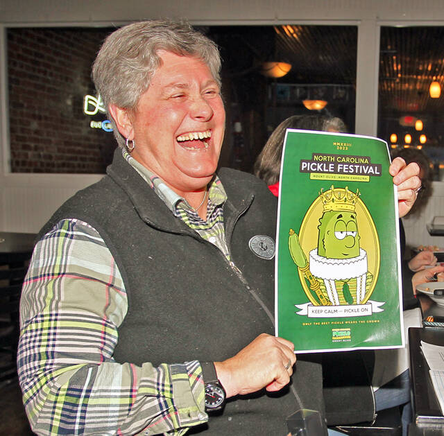 129299806_web1_Beck
Julie Beck, N.C. Pickle Festival co-chair, laughs as she holds up the logo for the 2023 N.C. Pickle Festival. Coordinated by the North Carolina Pickle Festival, Inc. in partnership with the Mount Olive Area Chamber of Commerce, the 37th annual N.C. Pickle Festival will be held from 5 p.m. to 10 p.m. Friday, April 28, and from 9 a.m. to 6 p.m. Saturday, April 29, in downtown Mount Olive (Steve Herring|mountolivetribune.com)