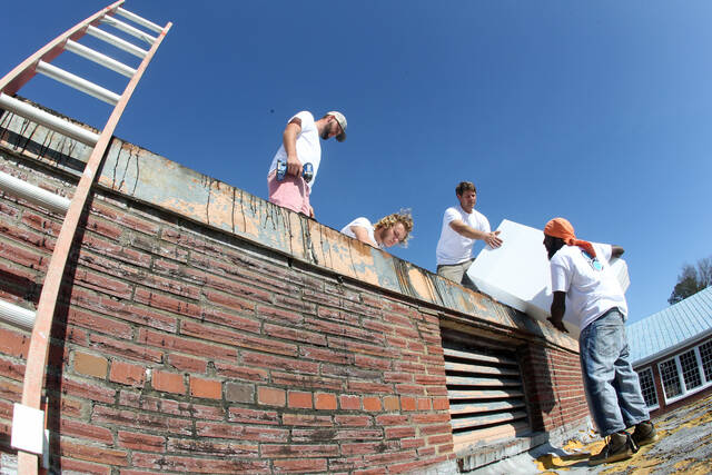129442023_web1_FIC-1
Deal Construction employees, left to right, Michael Schilling, Landon Deal, Jeffrey Deal (owner) and Demetrius Oates work on the roof of a wing of the old Carver High School. The wing is being renovated to serve as headquarters for the Men of Faith, Integrity and Character and will be dedicated in memory of the late Henrietta Highsmith Williams (Steve Herring|mountolivetribune.com)