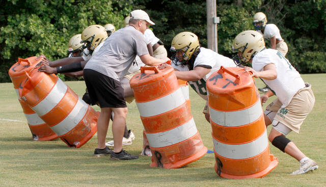 129871855_web1_RebelsFB18
North Duplin offensive coordinator Brad Rhodes works with the lineman during a practice drill. (Rudy Coggins|mountolivetribune.com)