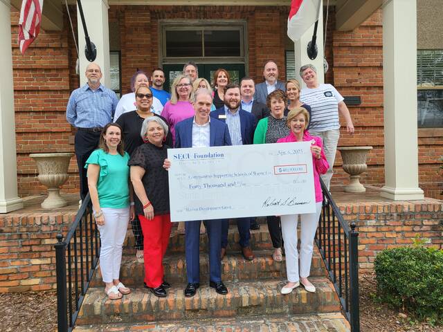 129887919_web1_SECU
Keith Marion, center, and Selena Bennett, right, display a symbolic check representing a $40,000 grant from the SECU Foundation to Communities Supporting Schools (CSS) of Wayne County. Marion is regional senior vice president of SECU; Bennett is executive director of CSS. Others pictured are: CSS board members; representatives from various Wayne County SECU branches; and, back row, far right, Julie Beck, president of the Mount Olive Area Chamber of Commerce. (Communities Supporting Schools of Wayne County|Courtesy photo)