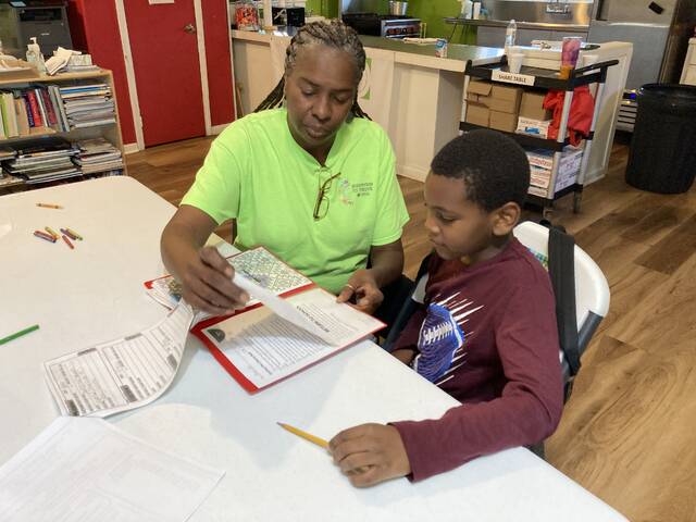 130142064_web1_dna-1
Founder and director of Diversity Nurtures Achievements (DNA) Community Youth Center Earlean Rivers checks homework just completed by Jacion, a student in the centers after-school care program. (Kathy Grant Westbrook|mountolivetribune.com)