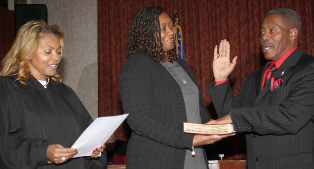 130225044_web1_mayor
Jerome Newton, right, takes the oath of office as mayor of Mount Olive as his daughter Tynisha Dawkins hold his Bible. Judge Ericka James, left, administered the oath during the town boards Tuesday, Dec. 12, session. (Steve Herring|mountolivetribune.com)