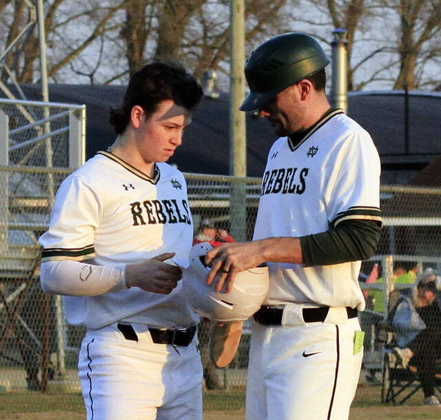 130461174_web1_NDBaseballColton
North Duplin head coach Colton Chrisman, right, gets equipment from Wesley Holmes during an inning change in a recent game. The Rebels are 3-2 after a home triumph over Wayne Christian on Friday. (Rudy Coggins|mountolivetribune.com)