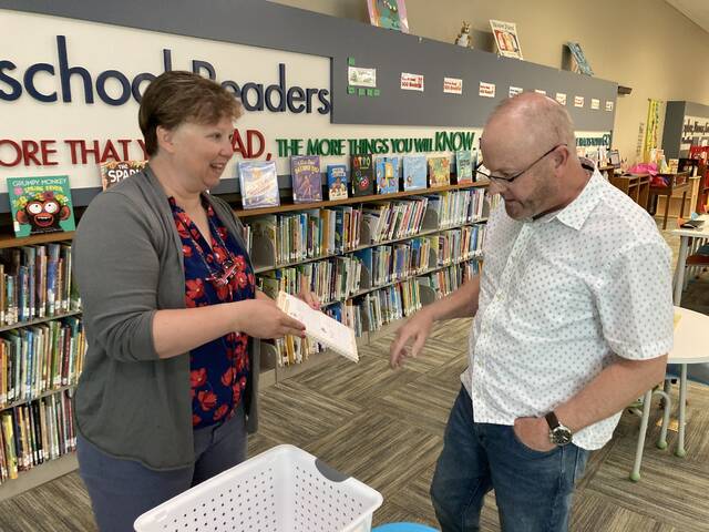 130684368_web1_library-ctr-1
Lauren Saeger, branch manager of Steele Memorial Library, shows Pastor Dennis Atwood, of First Baptist Mount Olive, a book that children can use to learn to write the letters of the alphabet. This book is one of many items included in the librarys new Learning Studio Resource Center, made possible by a $5000 donation from the church through its Gratitude Project. (Kathy Grant Westbrook|mountolivetribune.com)