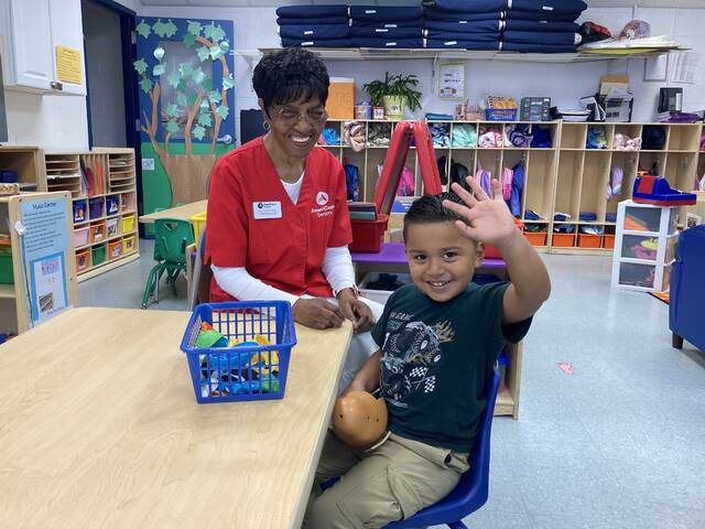 130921554_web1_foster-grands-1
Preschooler Pablo Deleon offers up a wave and a smile in his classroom at Carver Head Start. Sitting proudly by his side is Carolyn Ward, who volunteers 20 hours a week at the center, under the WAGES Foster Grandparent Program. All they want is a lot of love and affection, thats all they need, Ward says, of the children she mentors and tutors. Any senior (55 and older) interested in becoming a Foster Grandparent is encouraged to call 919-734-1178, ext. 202. (Kathy Grant Westbrook|mountolivetribune.com)