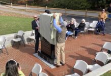 
			
				                                Simon Thornton (left) and Faison Mayor Billy Ward unveil a monument that pays tribute to Thornton’s father, William E. Thornton, a Faison native who became a physician, inventor, author, and astronaut. The monument is located on the site previously occupied by the town’s school gym and pays tribute to the school, as well. (Kathy Grant Westbrook|mountolivetribune.com)
 
			
		