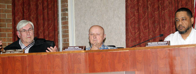 131274481_web1_Board
Mount Olive Commissioner Delreese Simmons, right, attempts to block Commissioner Danny Keel, center, from voting Thursday on a proposed contract with the Eastern Carolina Council to conduct a search for a new town manager. (Steve Herring|mountolivetribune.com)
