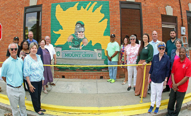 131461873_web1_Group
Mount Olives newest mural was unveiled during a brief Tuesday afternoon ceremony. Left to right are, Judson Pope, Pope Transport; Al and Deborah Southerland, Men of FIC, Rotary; Pam Brewer, building owner; Dave Sauls, Southern Bank; Lauren Saegar, Steele Memorial Library; Steve Wiggins, Mount Olive Community Development Corp. president; artist Winford Galmon; Jennifer Ricks Merritt, University of Mount Olive; Julie Beck, Mount Olive Area Chamber of Commerce president; Anna Hinson, Arts Council of Wayne County executive director; Bill Bryan, Mt. Olive Pickle Co.; Barbara Kornegay, Development Corp.; Ed Olive, UMO Agribusiness Center; Lynn Williams, N.C. Pickle Festival co-chair; and Mayor Jerome Newton. (Steve Herring|mountolivetribune.com)
