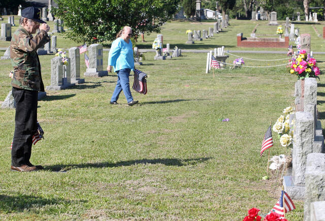 131539603_web1_Flags-salute
Vietnam veteran Robert Van Wormer salutes the flag he had just placed at the grave of a fellow Vietnam veteran Saturday morning at Oakview (Maplewood) Cemetery. Volunteers were busy placing flags on the graves of veterans ahead of Sundays annual Memorial Day observance and Memorial Day on Monday. In the background is his wife Sandra. (Steve Herring|mountolivetribune.com)