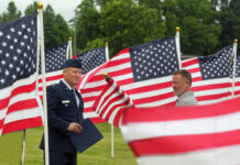
			
				                                Mount Olive Exchange Club member James Kornegay, right, gets a U.S. flag for his friend and Southern Wayne High School classmate, retired U.S. Air Force Col. Carlton Keen. Keen spoke Monday morning during the Exchange Club’s second annual Field of Heroes dedication ceremony. Keen, a veteran combat pilot, is a native of the Grantham community. (Steve Herring|mountolivetribune.com)
 
			
		