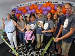 
			
				                                Brad Mitchell and Jennifer Bland use a large pair of ceremonial scissors Friday afternoon for the ribbon-cutting ceremony for the Mount Olive location of their Grounded and Baked bakery and coffee shop. The bakery features baked goods using the recipes Mitchell’s grandmother, Norma Ann “Nanny” Vinson, seated, taught him. From left are, Mount Olive Area Chamber of Commerce President Julie Beck; Chamber board Chairman Edward Olive; Mitchell’s wife, Wendy; Mount Olive town Commissioner Vicky Darden; Mitchell’s aunt, Debbie Hardy; Norma Ann “Nanny” Vinson; Mitchell’s mother, Dianne Mitchell; Chamber Ambassador Pernell Brickey; Mitchell; Bland and her daughter, Collins; son, Andrew; and husband Frank. The business is located in the old Henderson-Crumpler Clinic, 229 N. Center St. (Steve Herring|mountolivetribune.com)
 
			
		