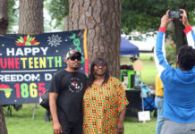 
			
				                                Isaiah Whitfield stretches to take a photo of his parents, Michael and Fransha Whitfield, as they pose in front a banner celebrating Juneteenth. The Whitfields were among the hundreds who attended Saturday’s fourth annual Community Juneteenth Celebration sponsored by the Mount Olive Chapter of the Carver High School Alumni and Friends Association. (Steve Herring|mountolivetribune.com)
 
			
		