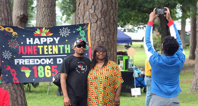131586082_web1_Juneteenth-selfie
Isaiah Whitfield stretches to take a photo of his parents, Michael and Fransha Whitfield, as they pose in front a banner celebrating Juneteenth. The Whitfields were among the hundreds who attended Saturdays fourth annual Community Juneteenth Celebration sponsored by the Mount Olive Chapter of the Carver High School Alumni and Friends Association. (Steve Herring|mountolivetribune.com)
