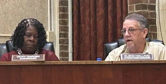 
			
				                                Interim Mount Olive Town Manager Glenn Holland, right, gives his report to the board while District 1 Commissioner Vicky Darden listens. (Georgia Martin Dees|mountolivetribune.com)
 
			
		