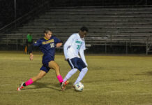 
			
				                                No. 32 Christopher Mulenga Miteu, battles hard for control as he powers through the Cougars’ defense, commanding the ball with intensity and determination. (Kareem Brown|mountolivetribune.com)
 
			
		