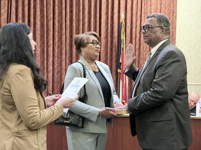 Mount Olive town clerk Sherry Davis administers the oath to newly hired town manager Octavius Murphy. Holding the Bible is his wife, Jacqueline. (Georgia Dees|mountoilvetribune.com)