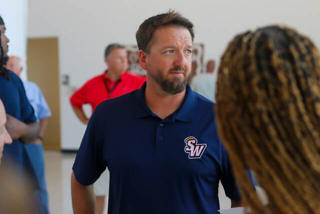 Southern Wayne Saints newly appointed Mens Basketball Head Coach Austin Hood, talking with parents and Saints Alumni at the Meet the Coach Event.